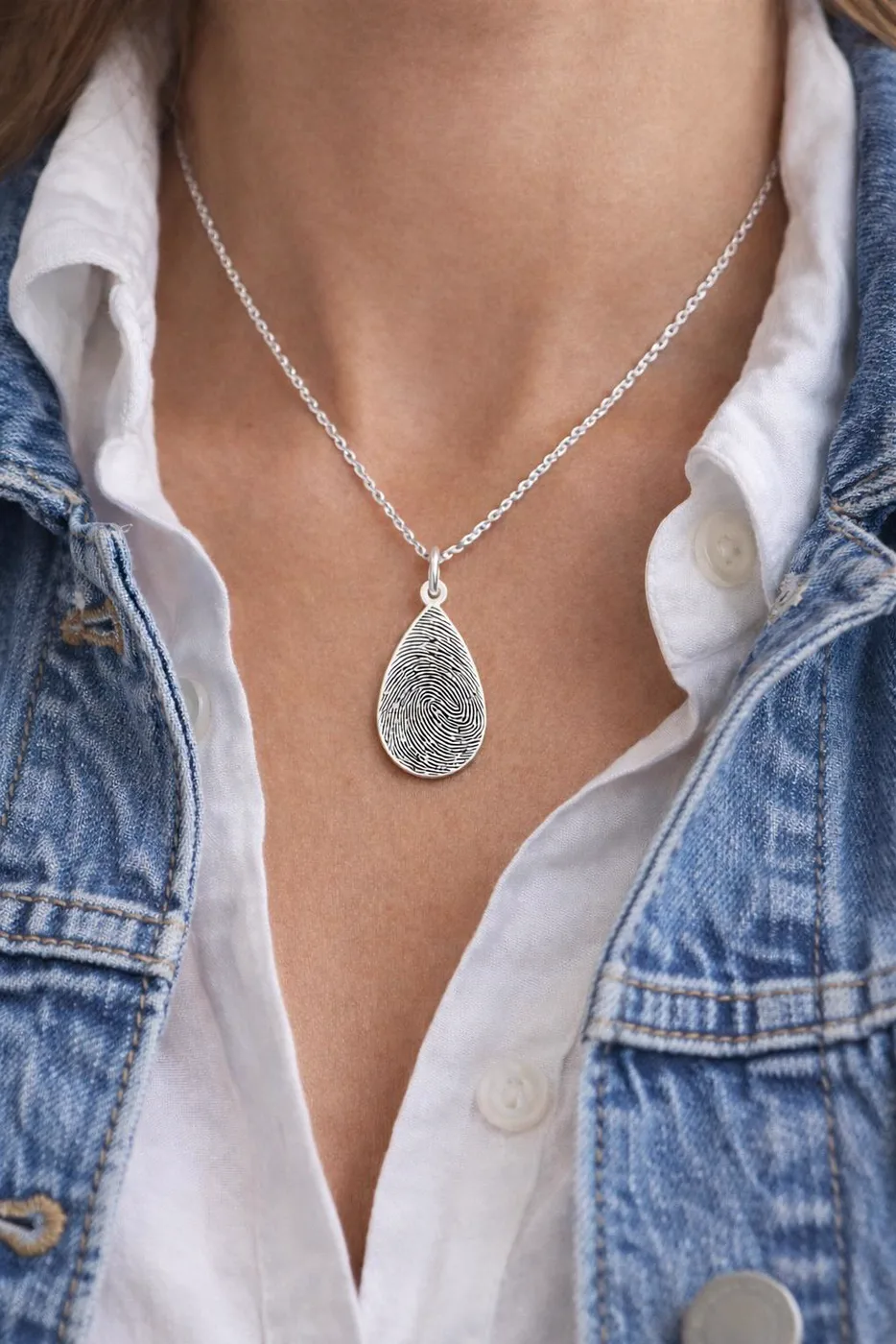 The teardrop pendant worn over a denim jacket
