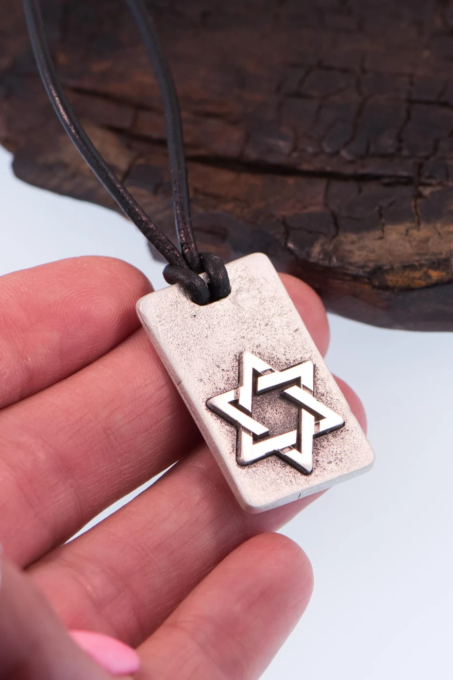 Masculine Star of David dog tag held