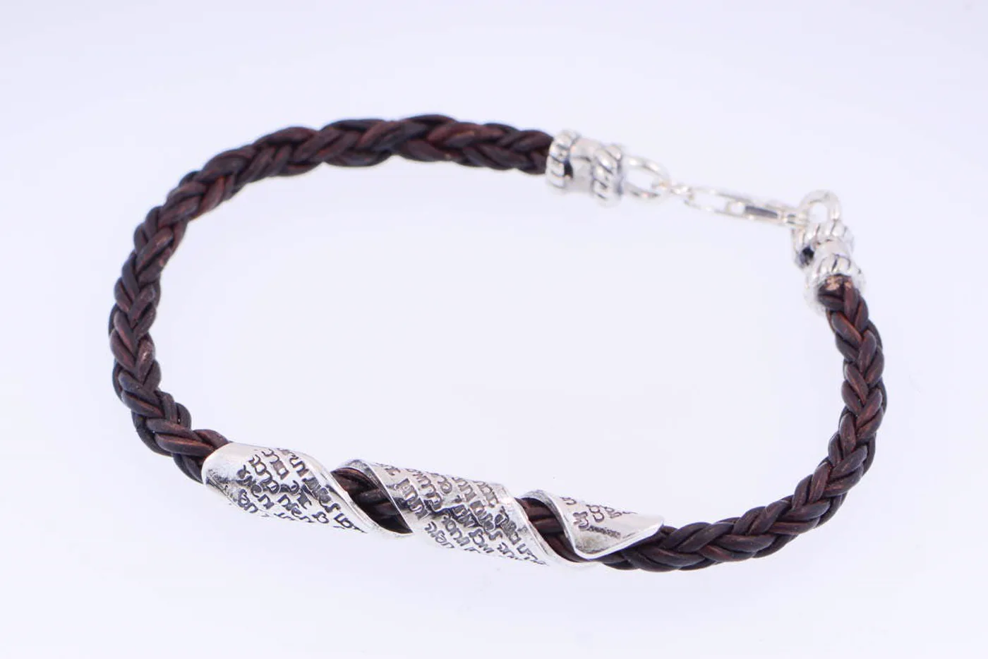 The full bracelet laid open, showing the silver clasp and the inscribed plate