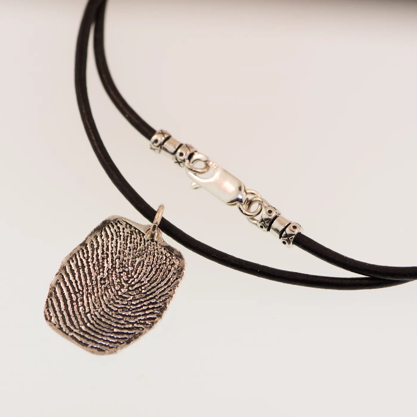 The same charm on a black leather cord
